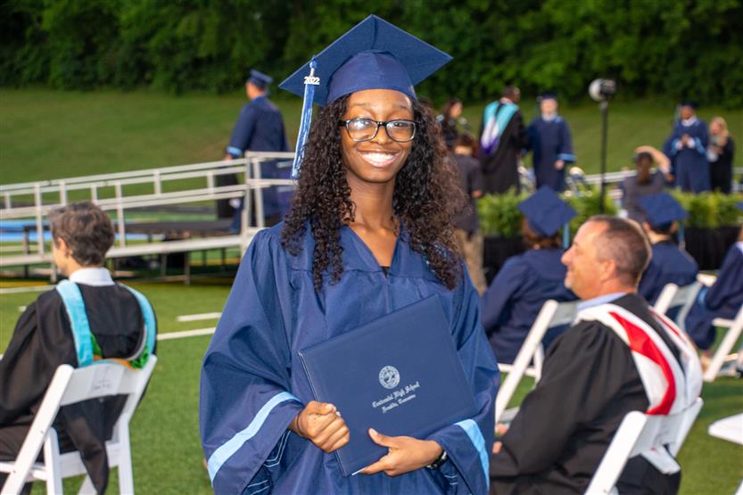 Students graduate outside on a football field